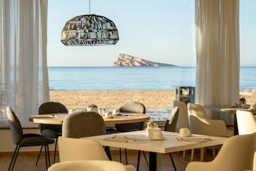 a room with tables and chairs on a beach