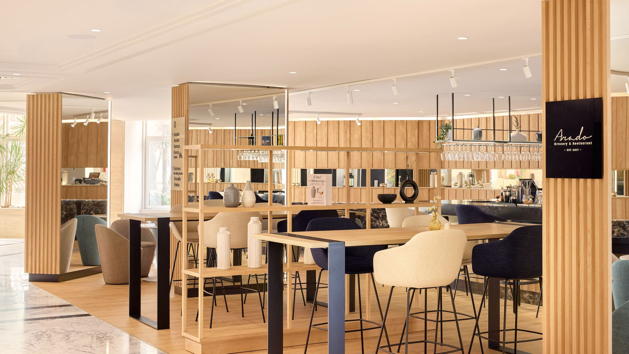 Bar moderno Arado con muebles de madera, taburetes altos y estanterías.
