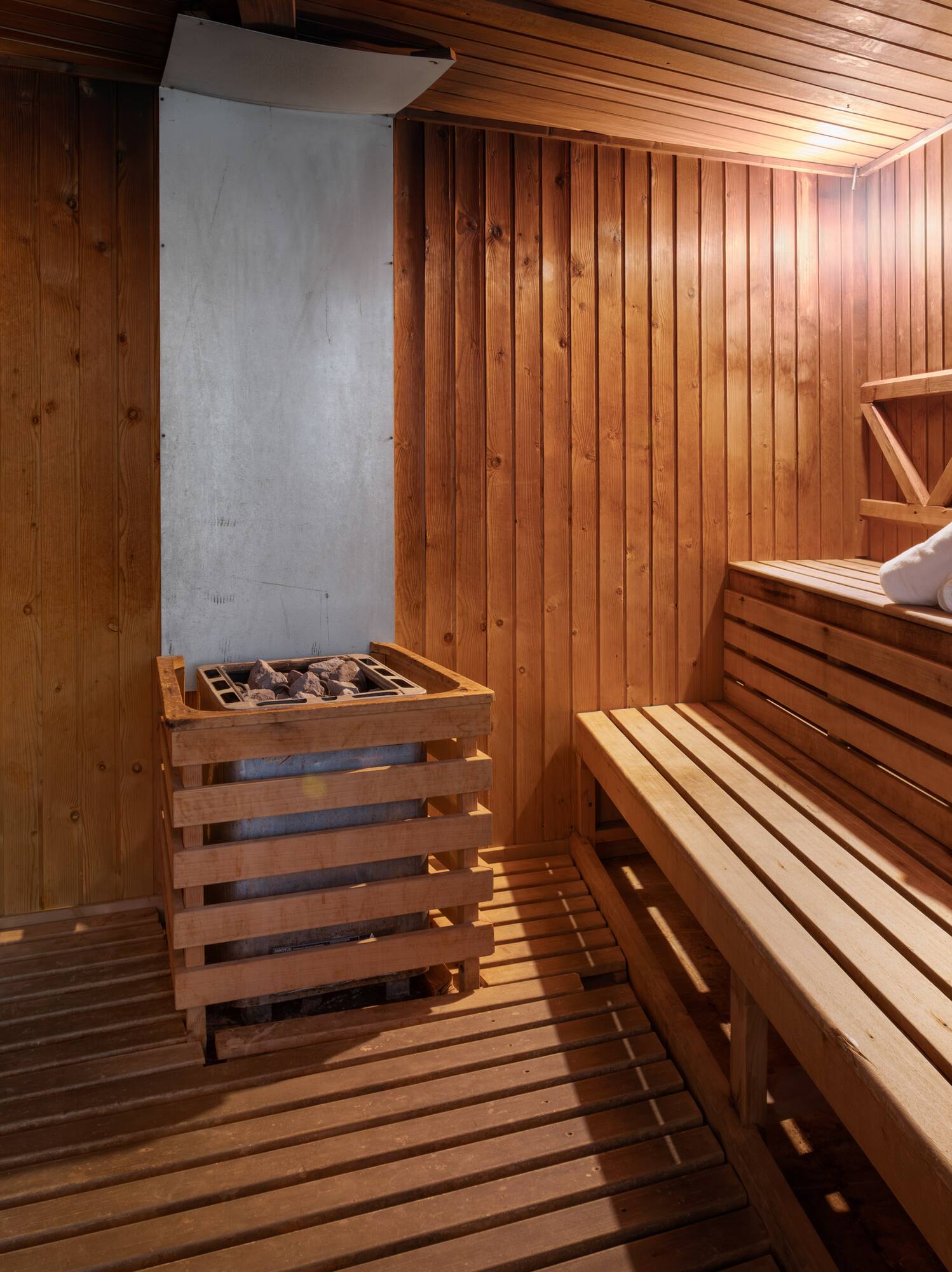 Sauna de madera, calentador de piedras y toallas. Relajación y spa.