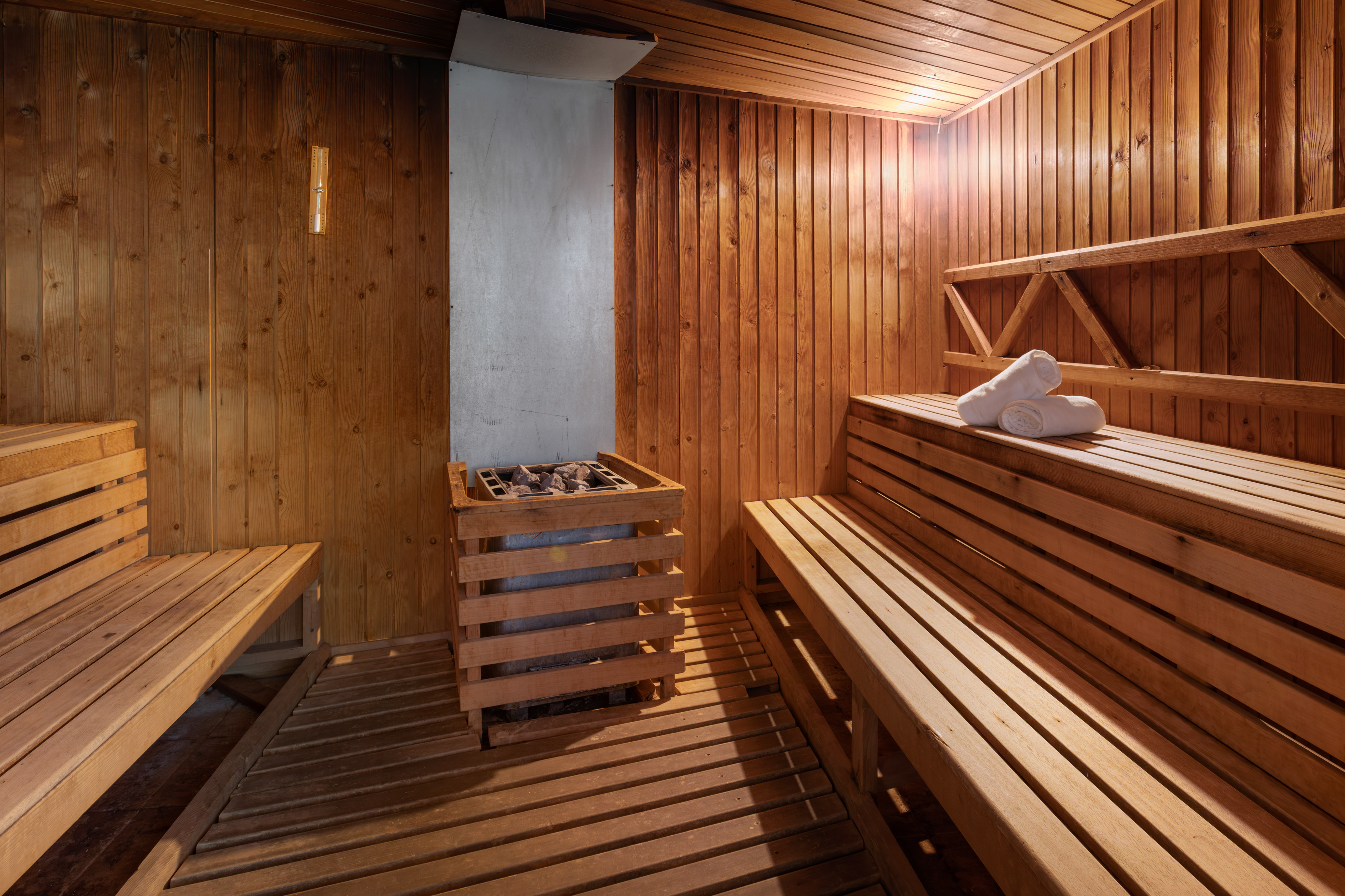 Sauna de madera, calentador de piedras y toallas. Relajación y spa.