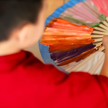 a boy painting a fan