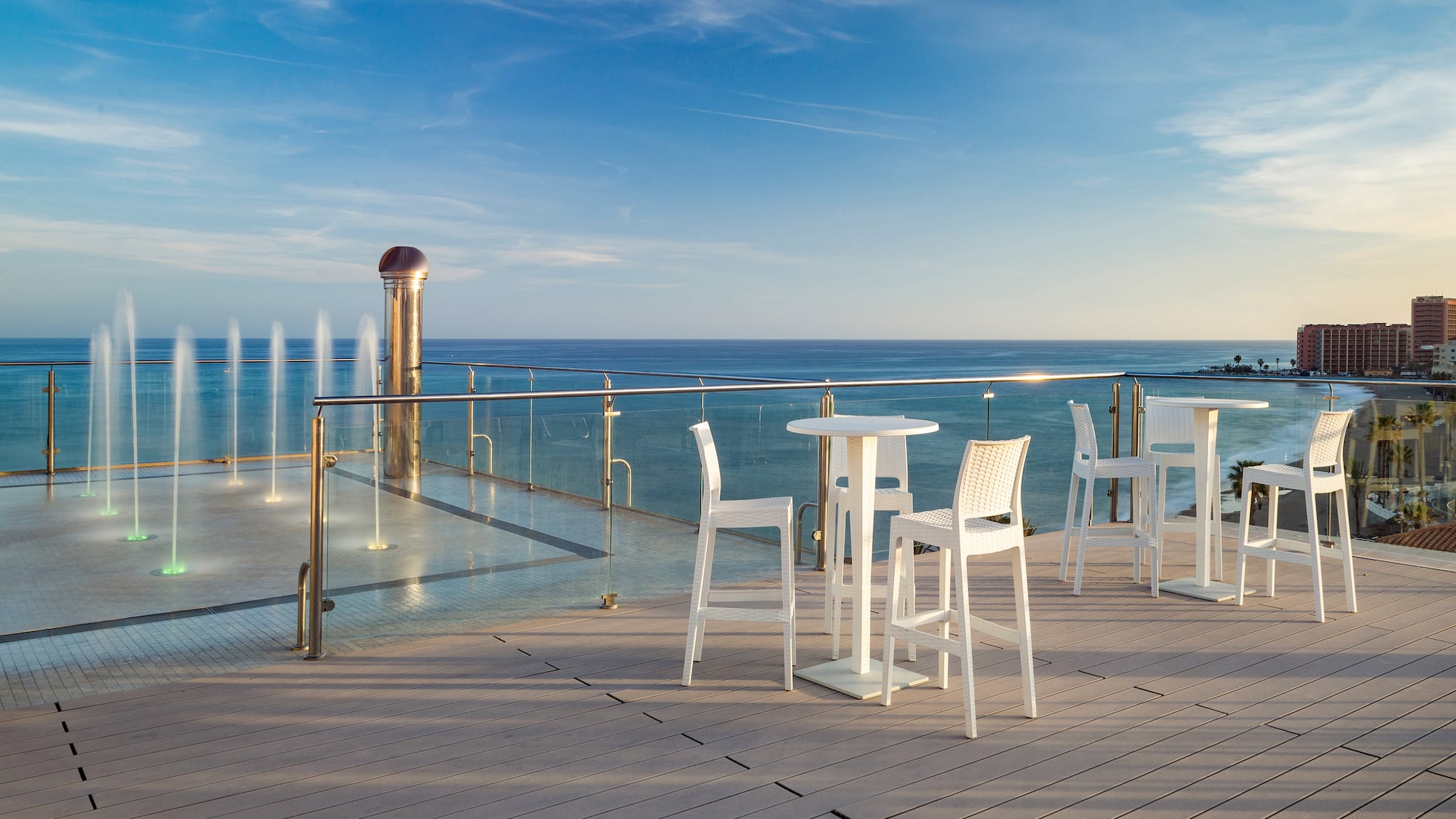 a table and chairs on a deck overlooking the ocean