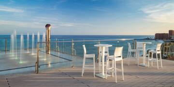 a table and chairs on a deck overlooking the ocean