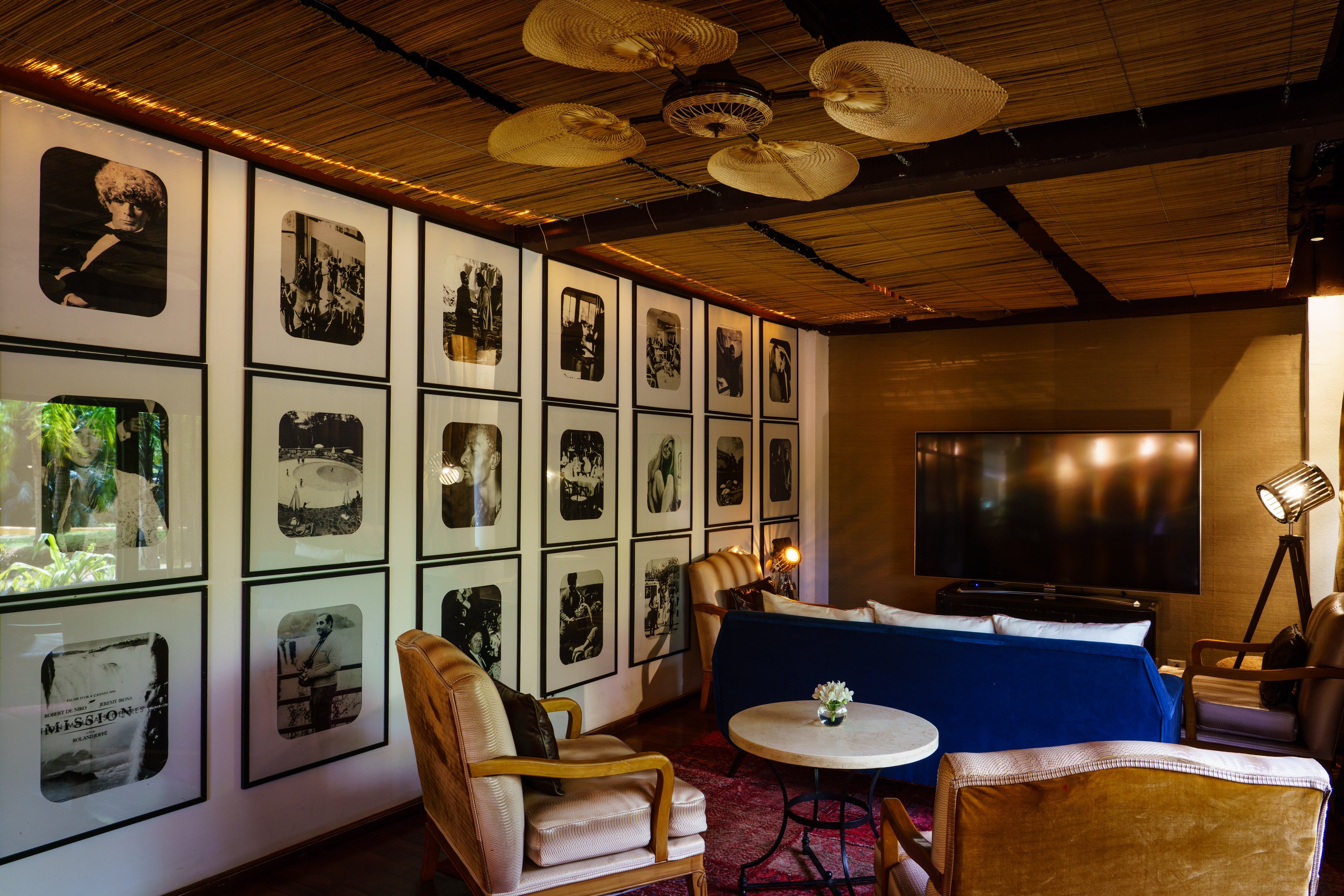 Eclectic living room: photo gallery wall, bamboo ceiling, vintage furniture.