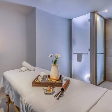 a massage table with towels and a vase of flowers