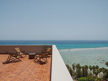 chairs on a balcony overlooking a body of water