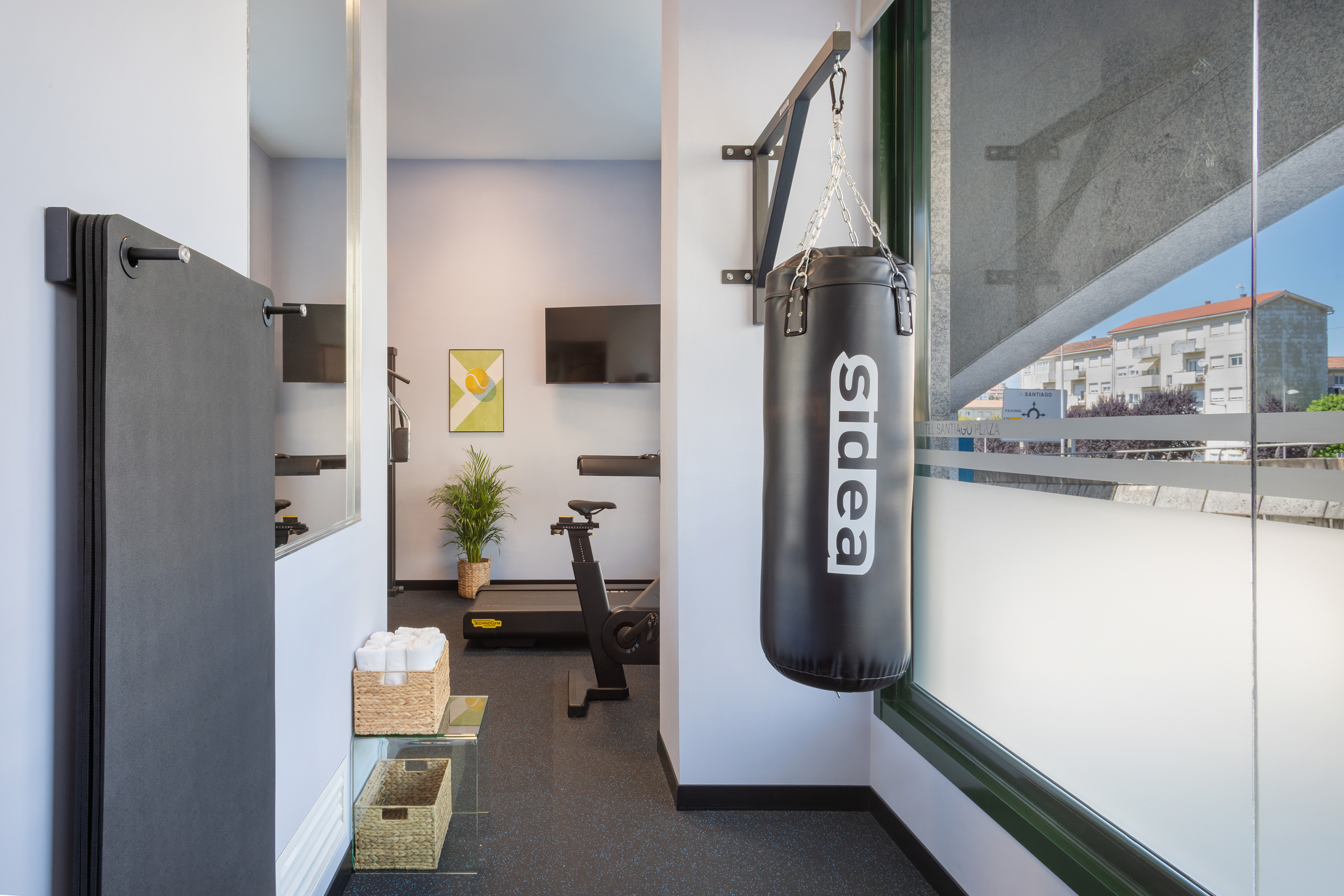 Hotel fitness room with punching bag, treadmill, and yoga mats.