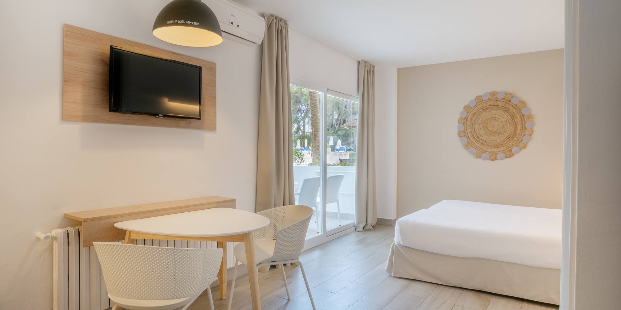 a room with a bed and a table and chairs