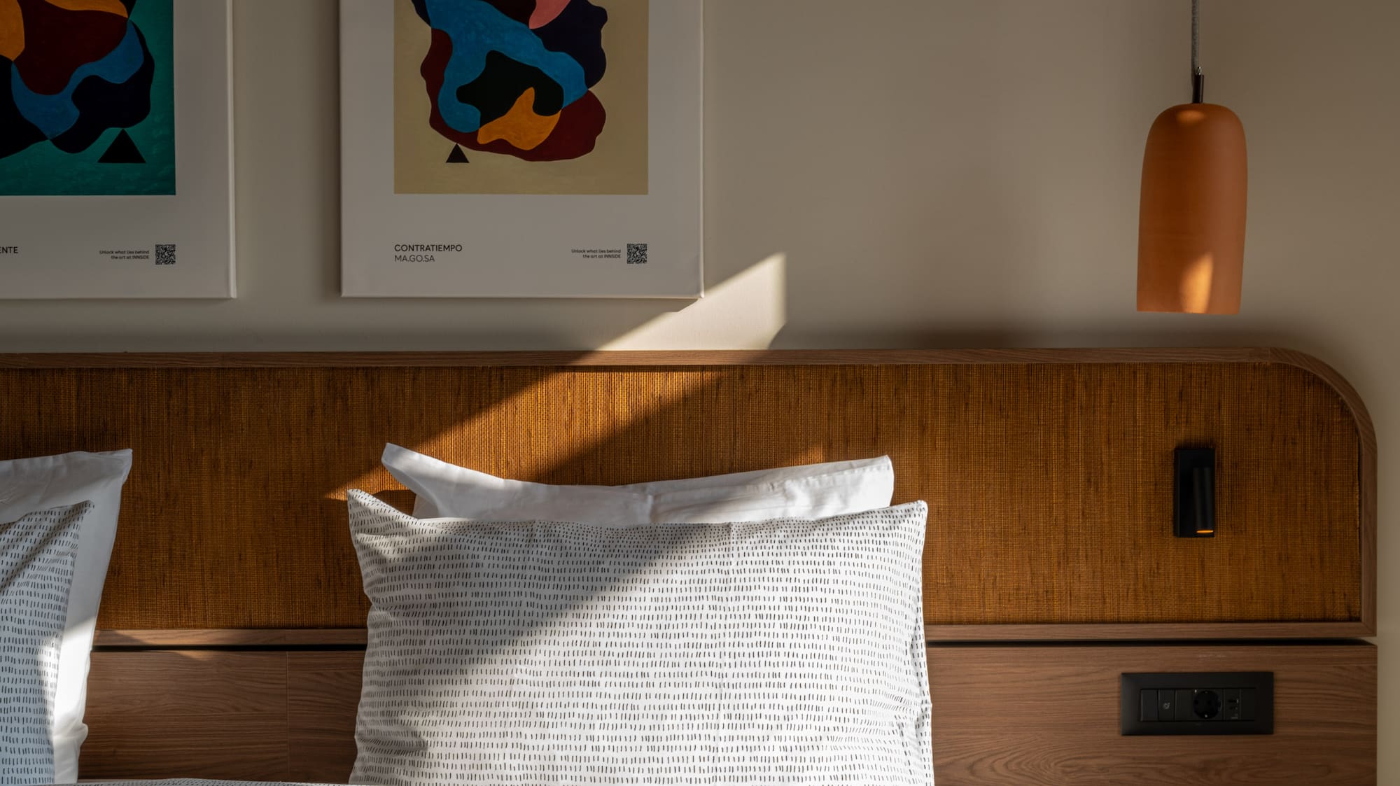 a bed with pillows and a lamp