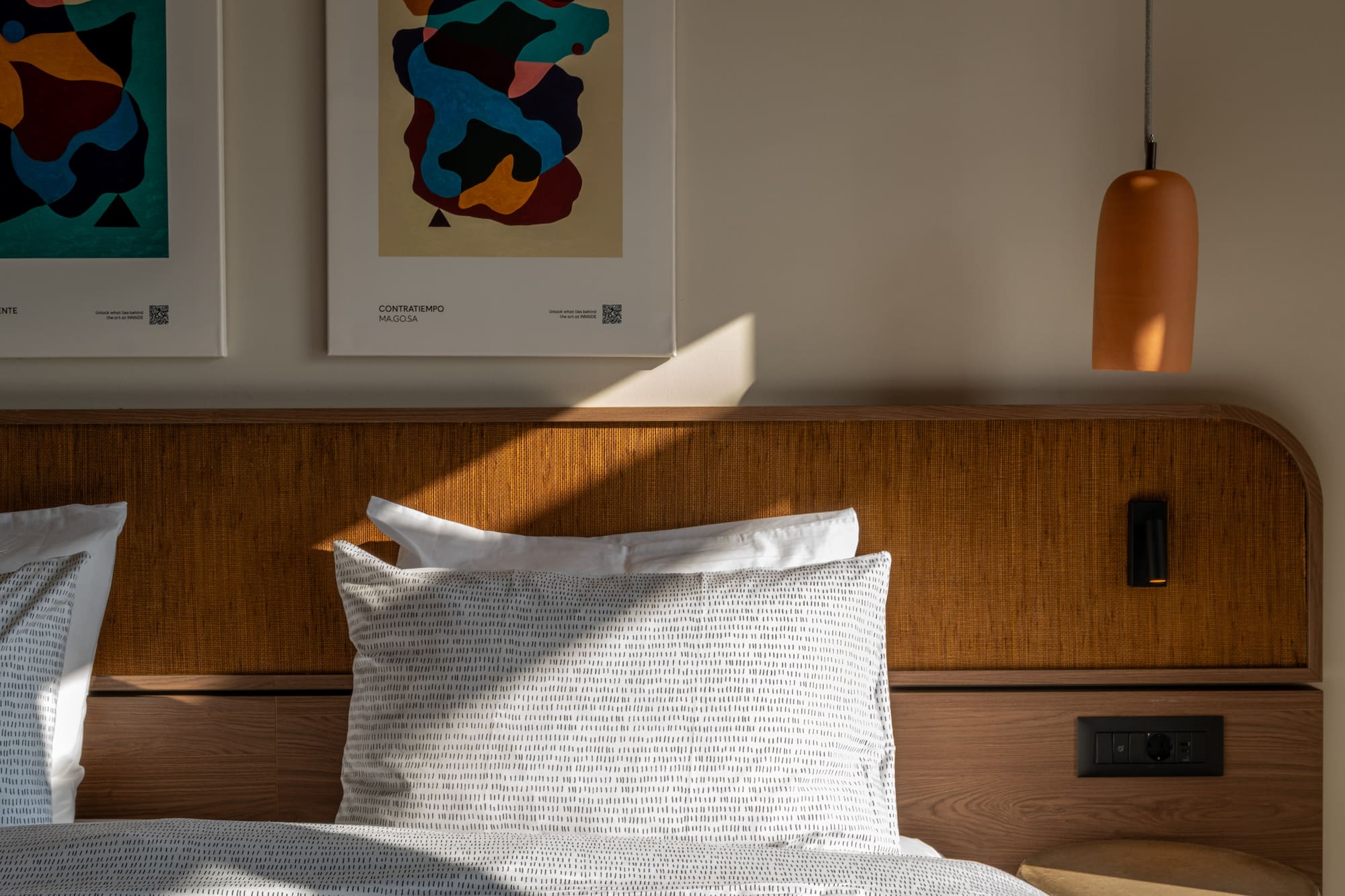 a bed with pillows and a lamp