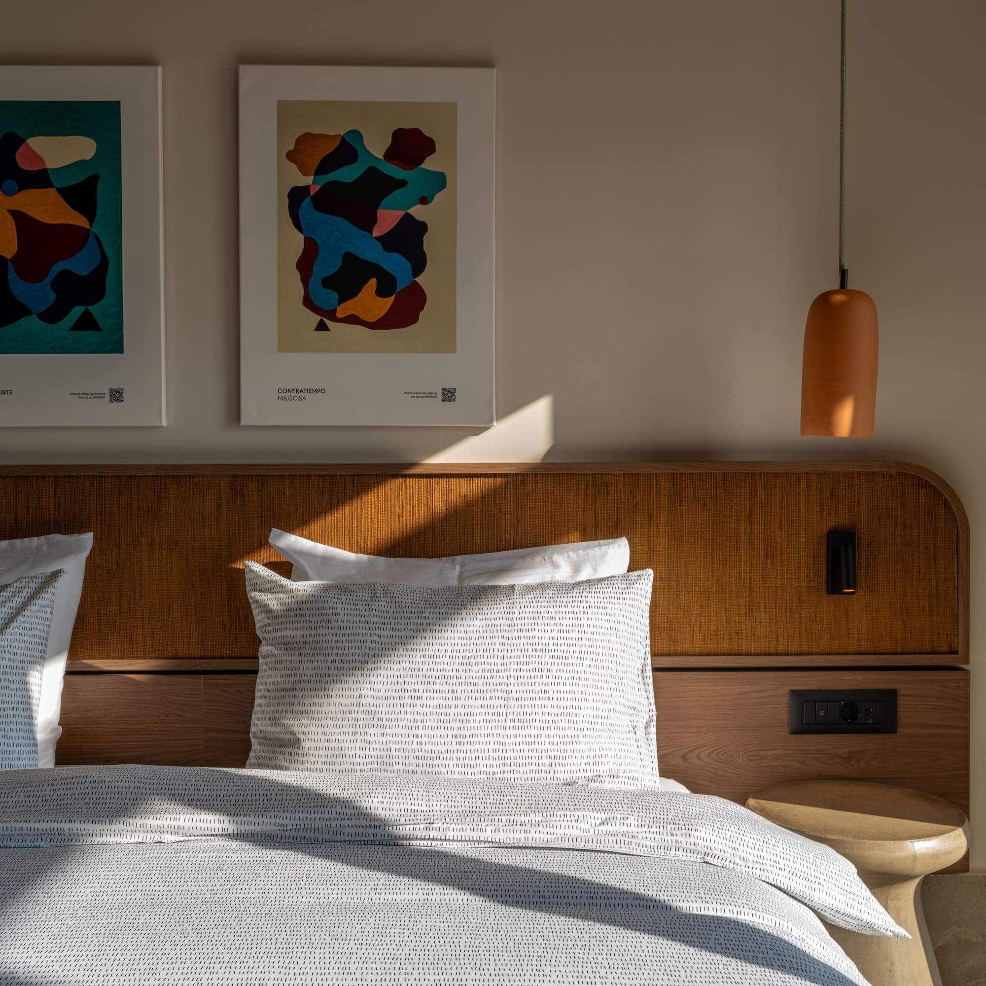 a bed with pillows and a lamp