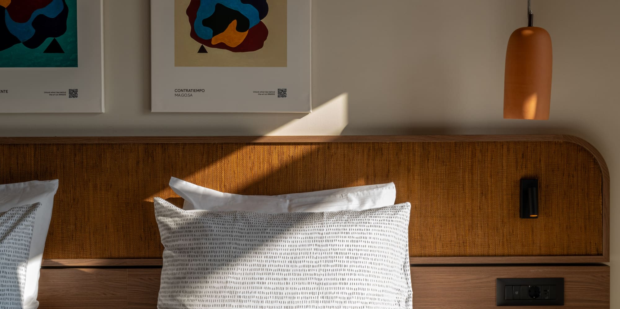 a bed with pillows and a lamp