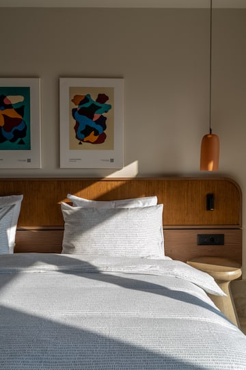 a bed with pillows and a lamp