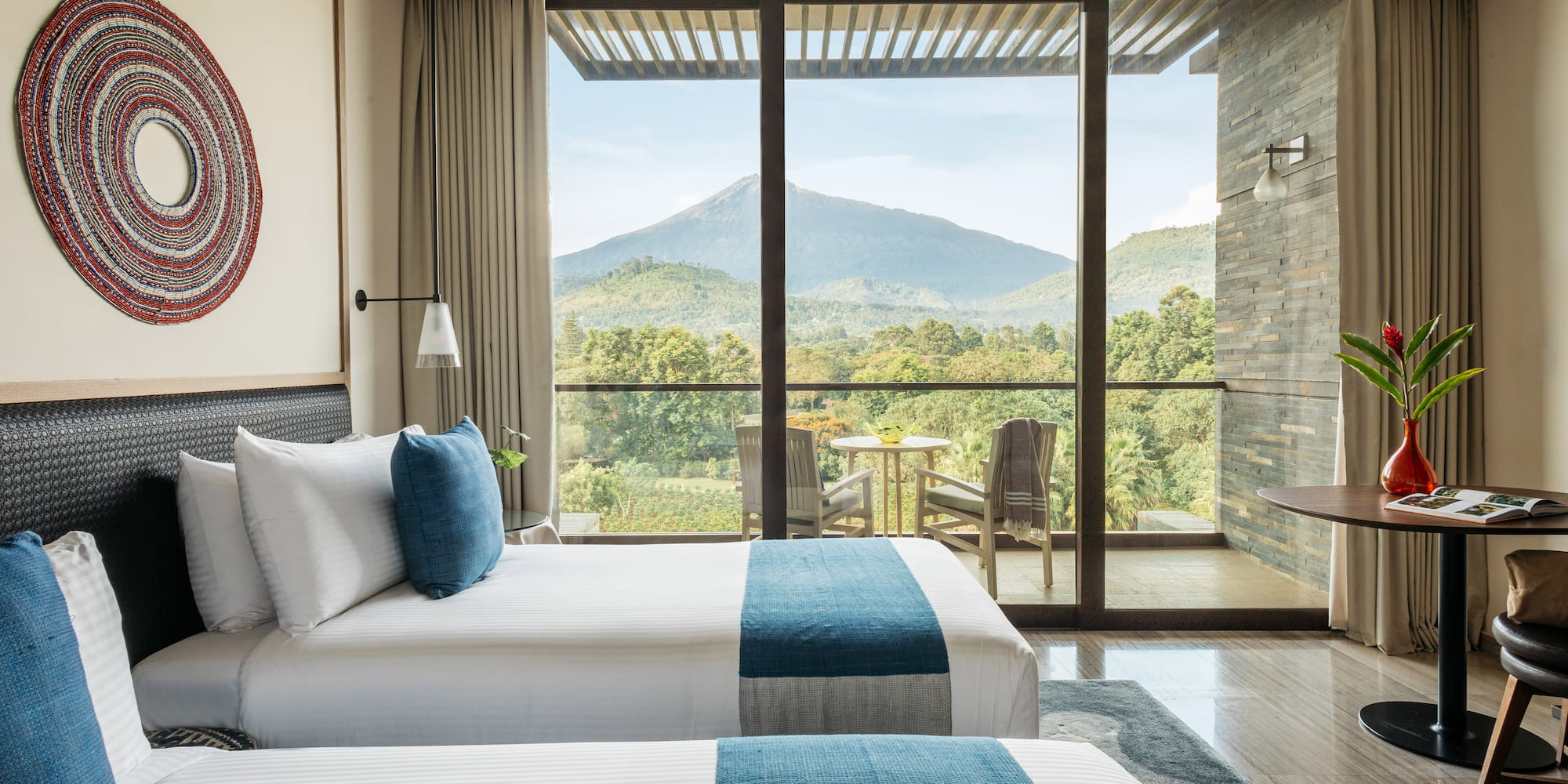 Luxury hotel room with twin beds, volcano view balcony.
