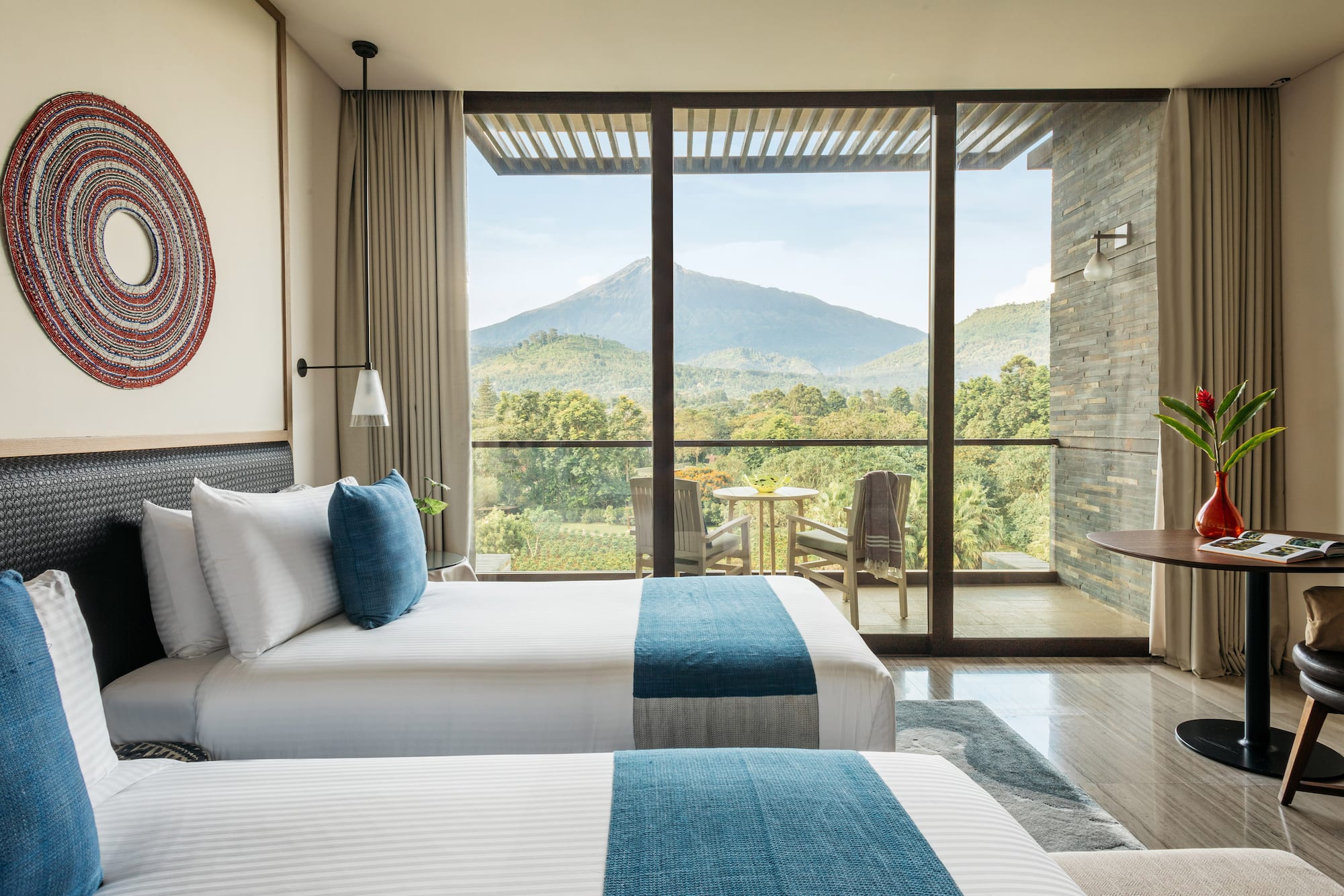 Luxury hotel room with twin beds, volcano view balcony.