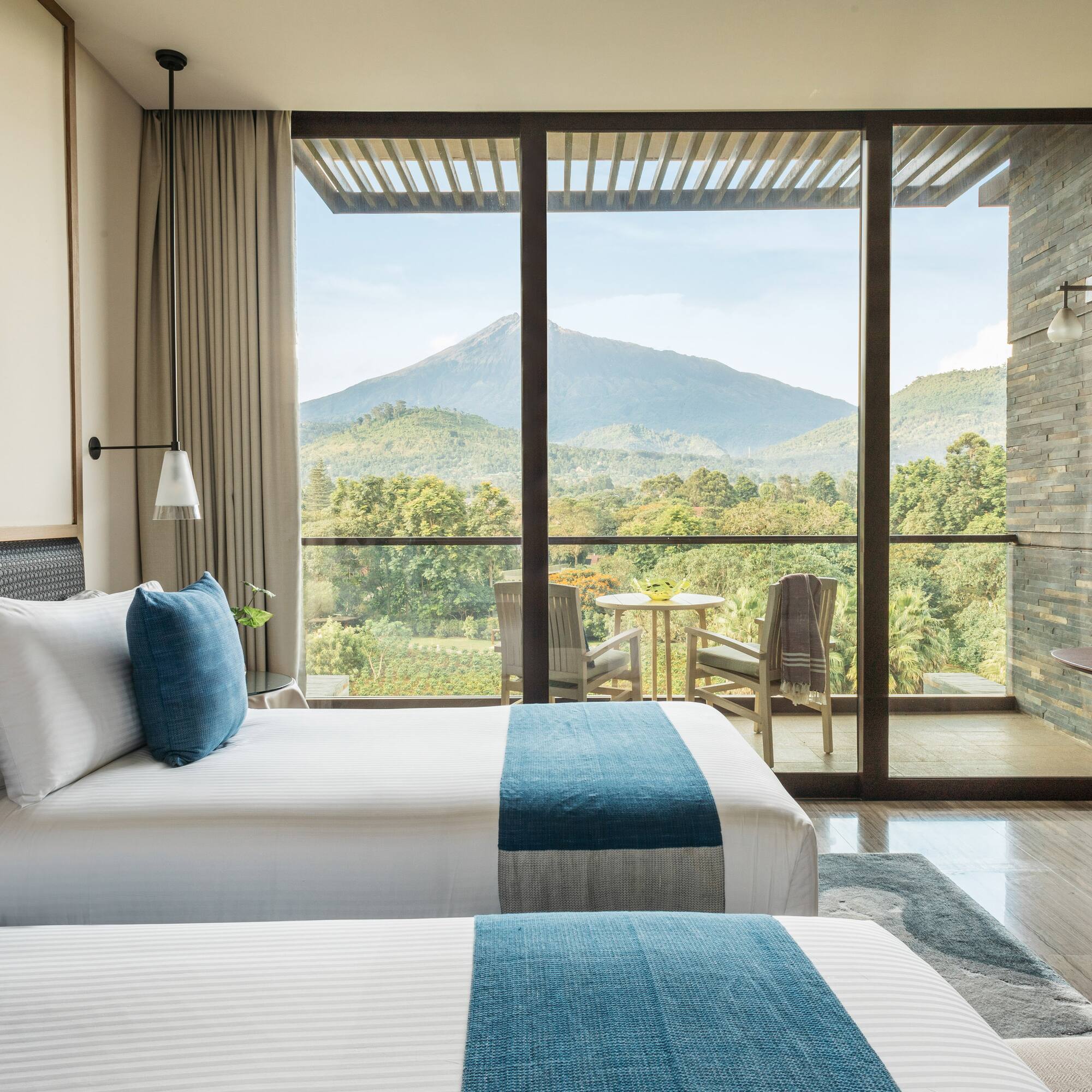Luxury hotel room with twin beds, volcano view balcony.