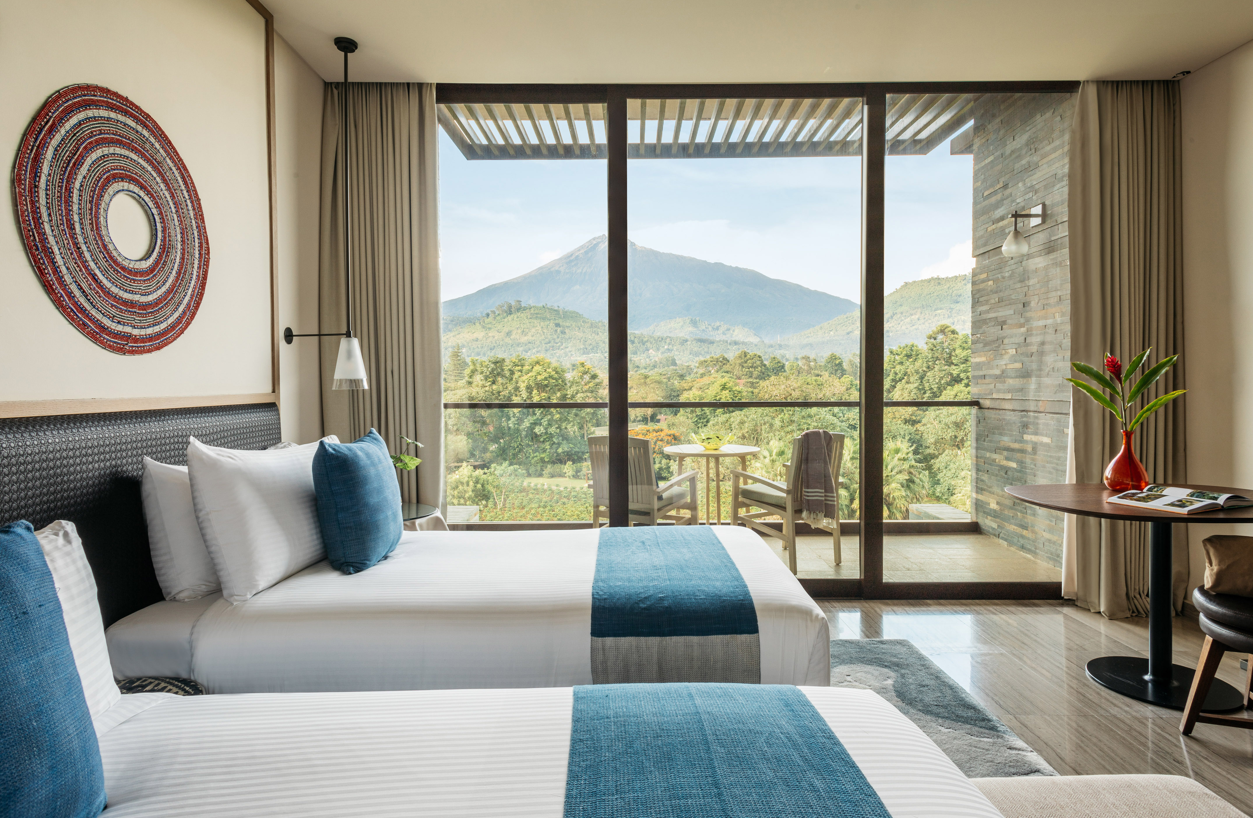 Luxury hotel room with twin beds, volcano view balcony.