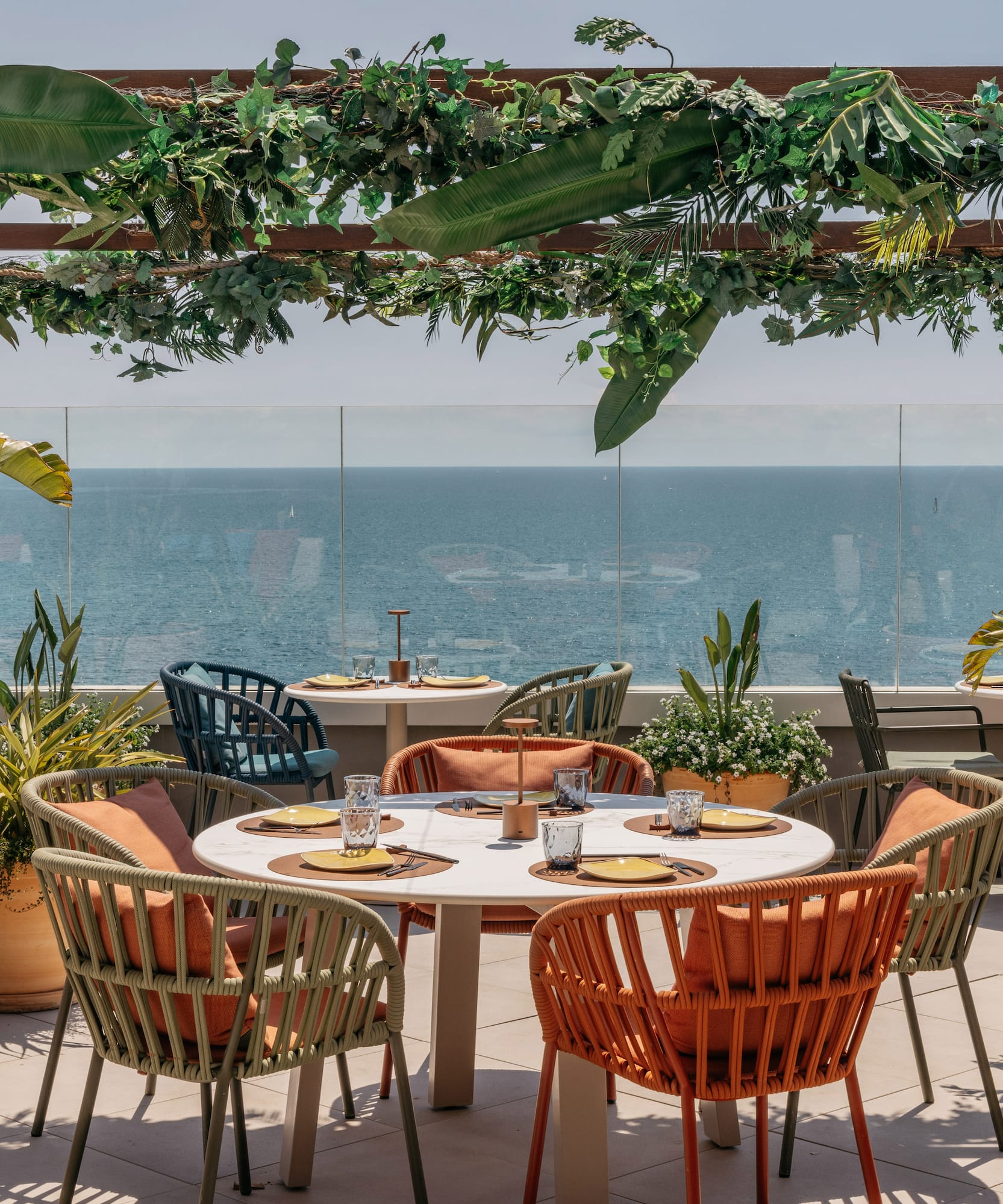 a table and chairs on a patio overlooking the ocean