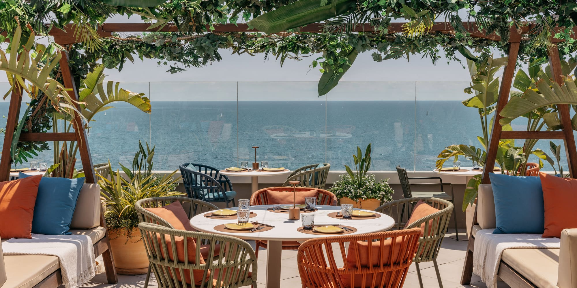 a table and chairs on a patio overlooking the ocean