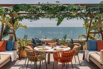 a table and chairs on a patio overlooking the ocean