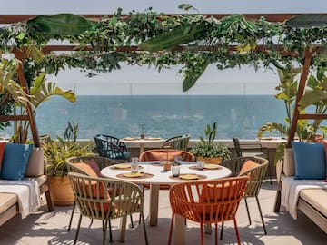 a table and chairs on a patio overlooking the ocean