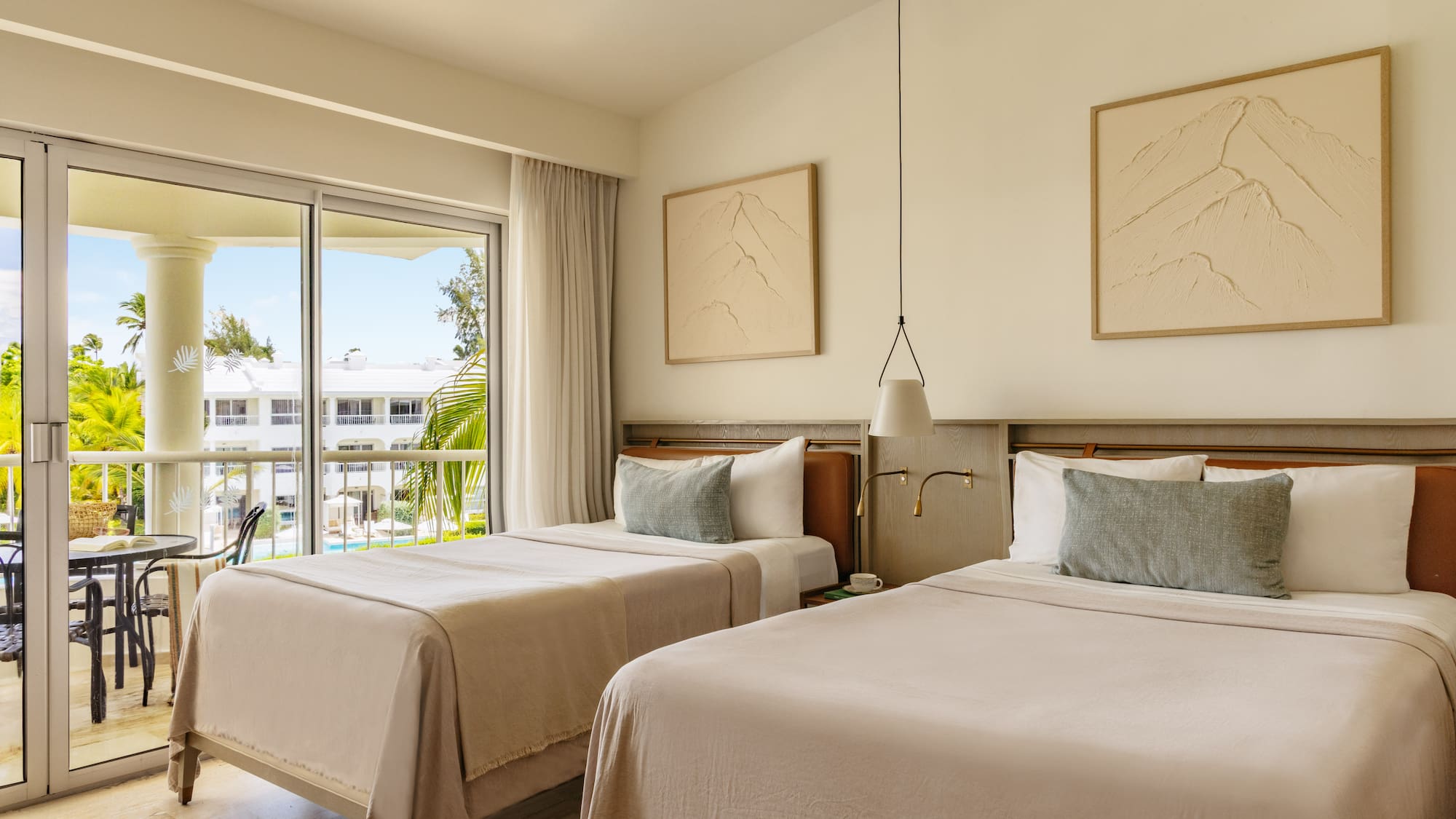 Modern resort room with twin beds, balcony, and tropical palm tree view.