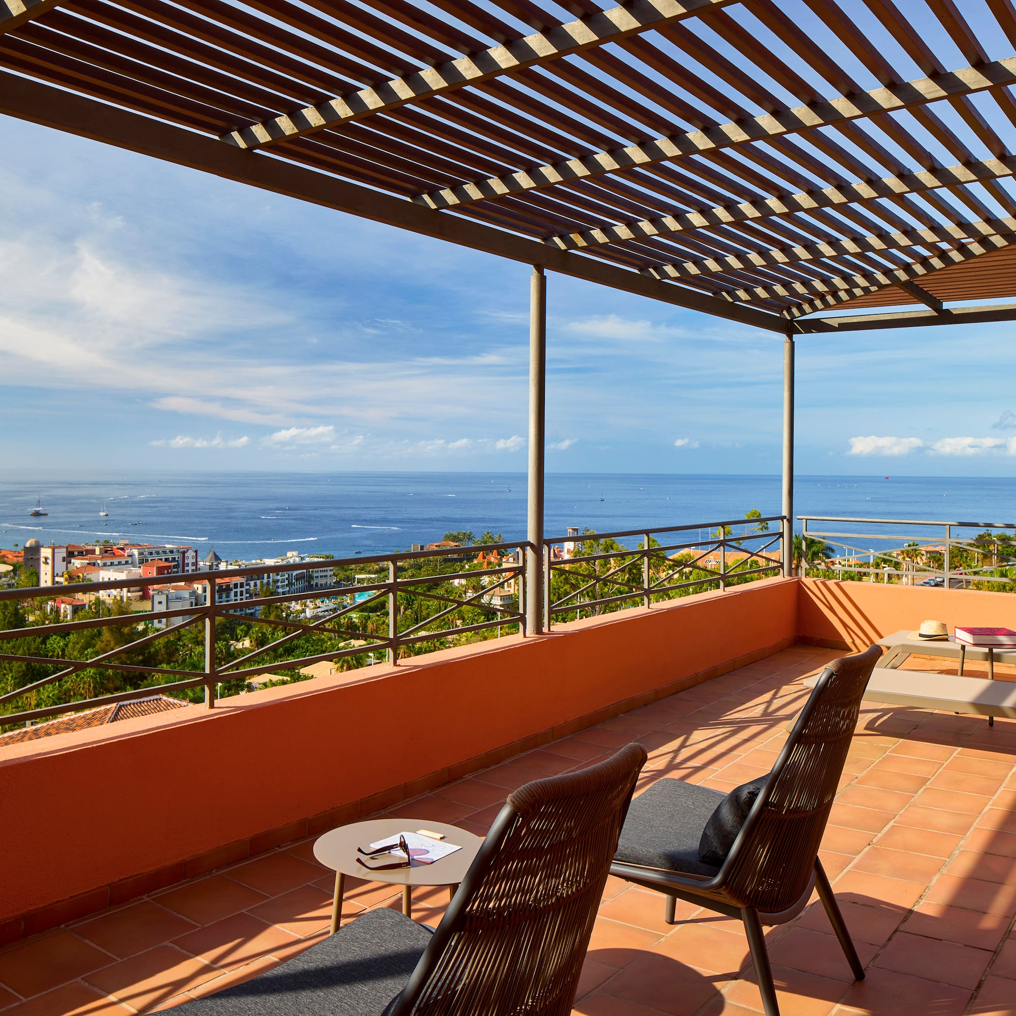 a patio with chairs and a view of the ocean