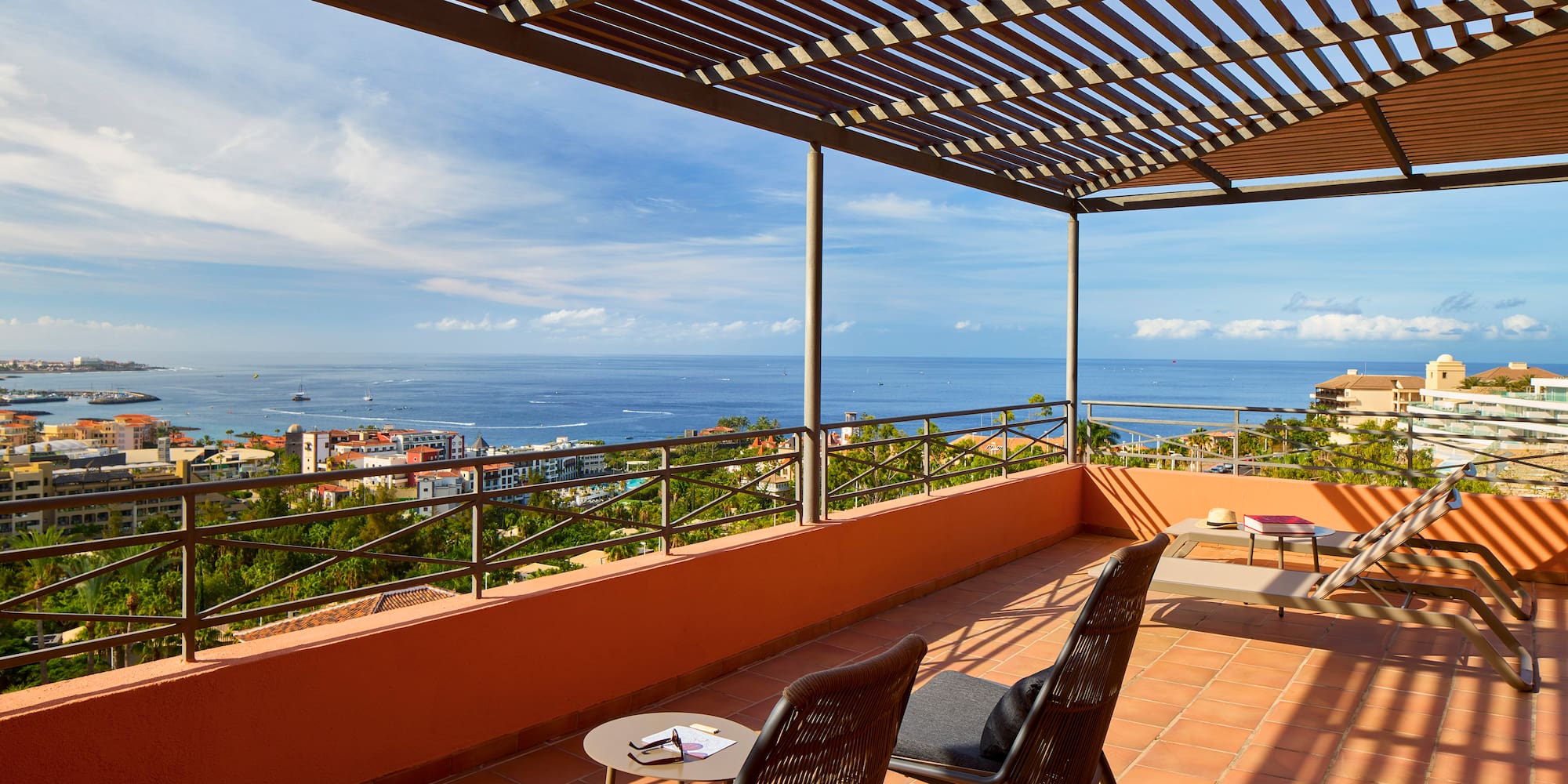 a patio with chairs and a view of the ocean