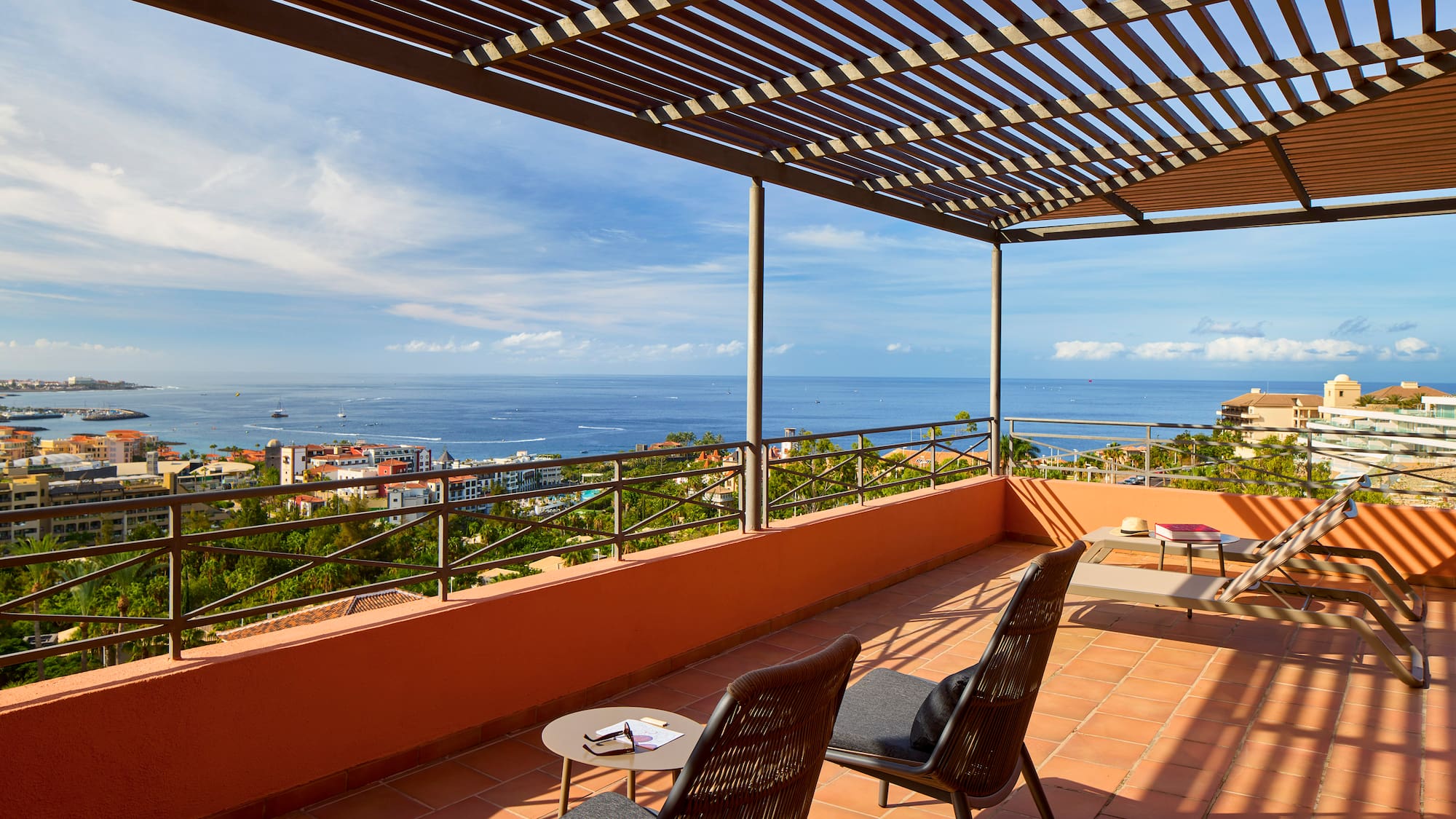a patio with chairs and a view of the ocean