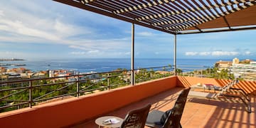 a patio with chairs and a view of the ocean