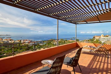 a patio with chairs and a view of the ocean