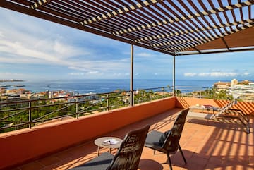 a patio with chairs and a view of the ocean