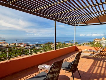 a patio with chairs and a view of the ocean