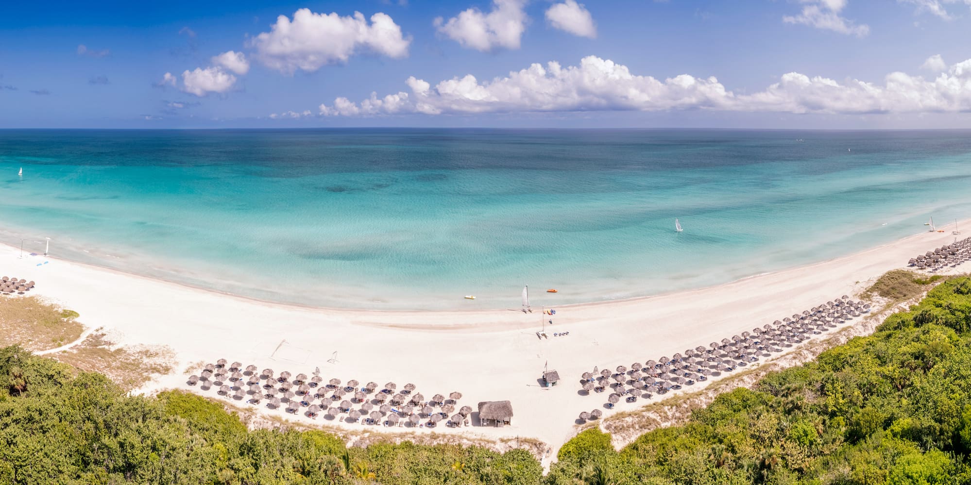 a beach with umbrellas and a body of water