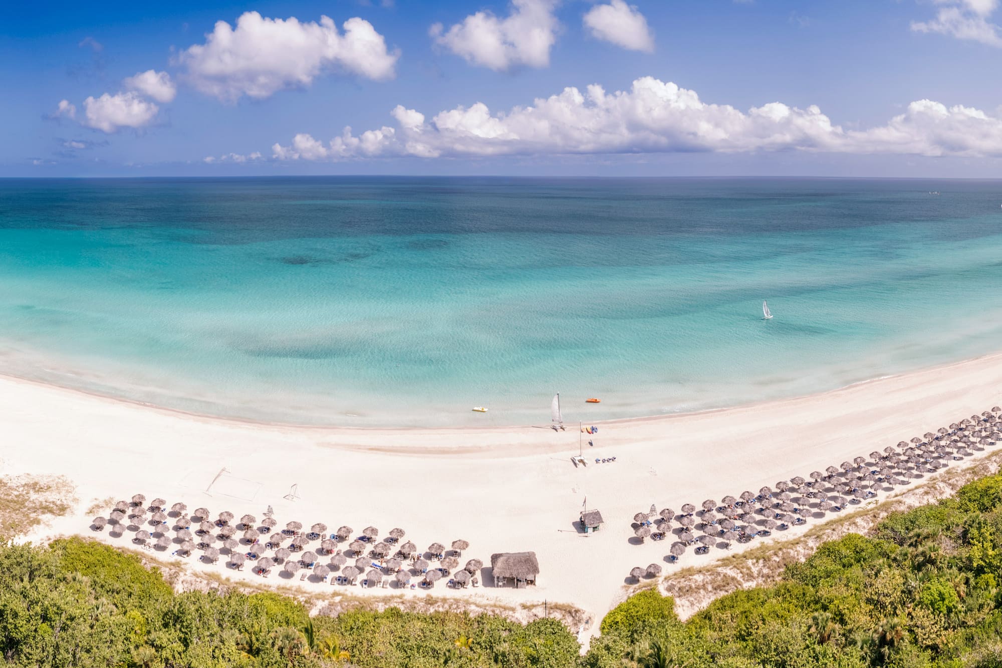 a beach with umbrellas and a body of water