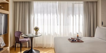 a room with a bed and a table and chairs