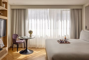 a room with a bed and a table and chairs