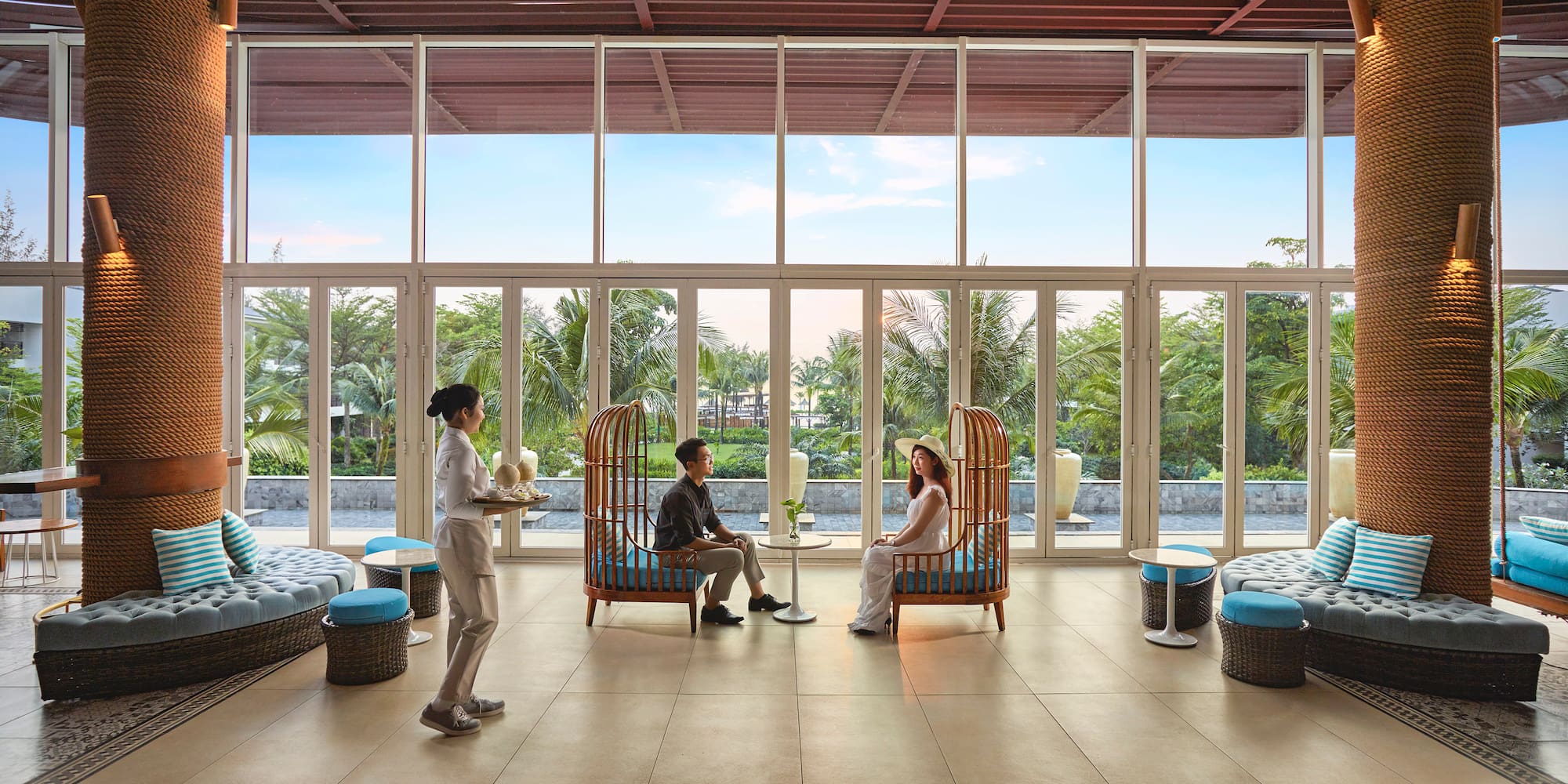 a group of people sitting in a room with large windows