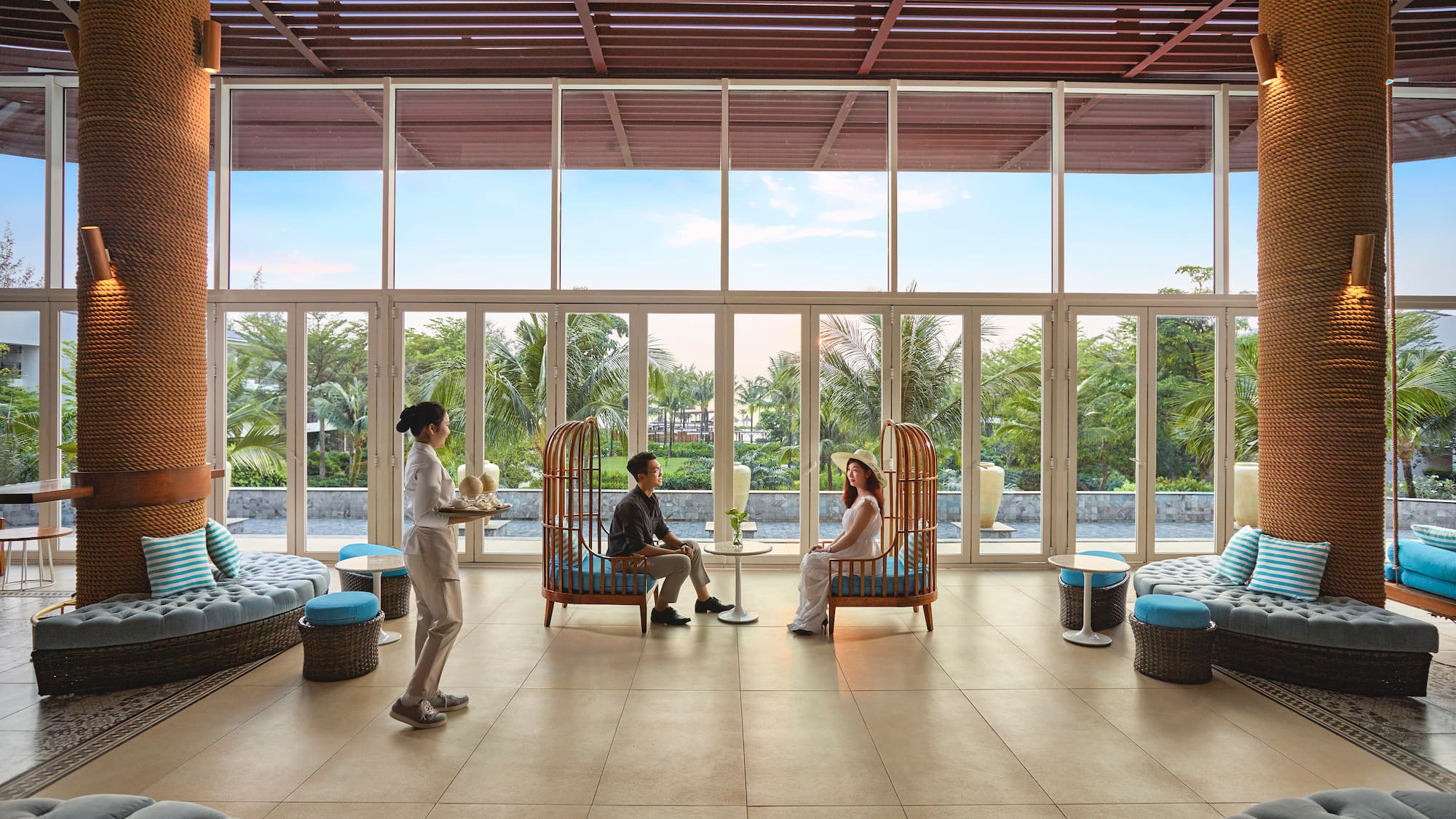 a group of people sitting in a room with large windows