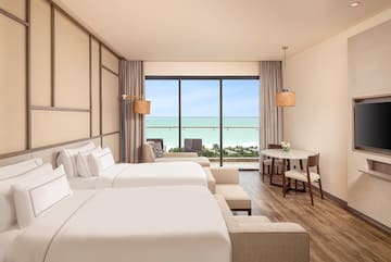 a room with two beds and a table and chairs