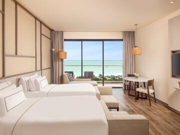 a room with two beds and a table and chairs