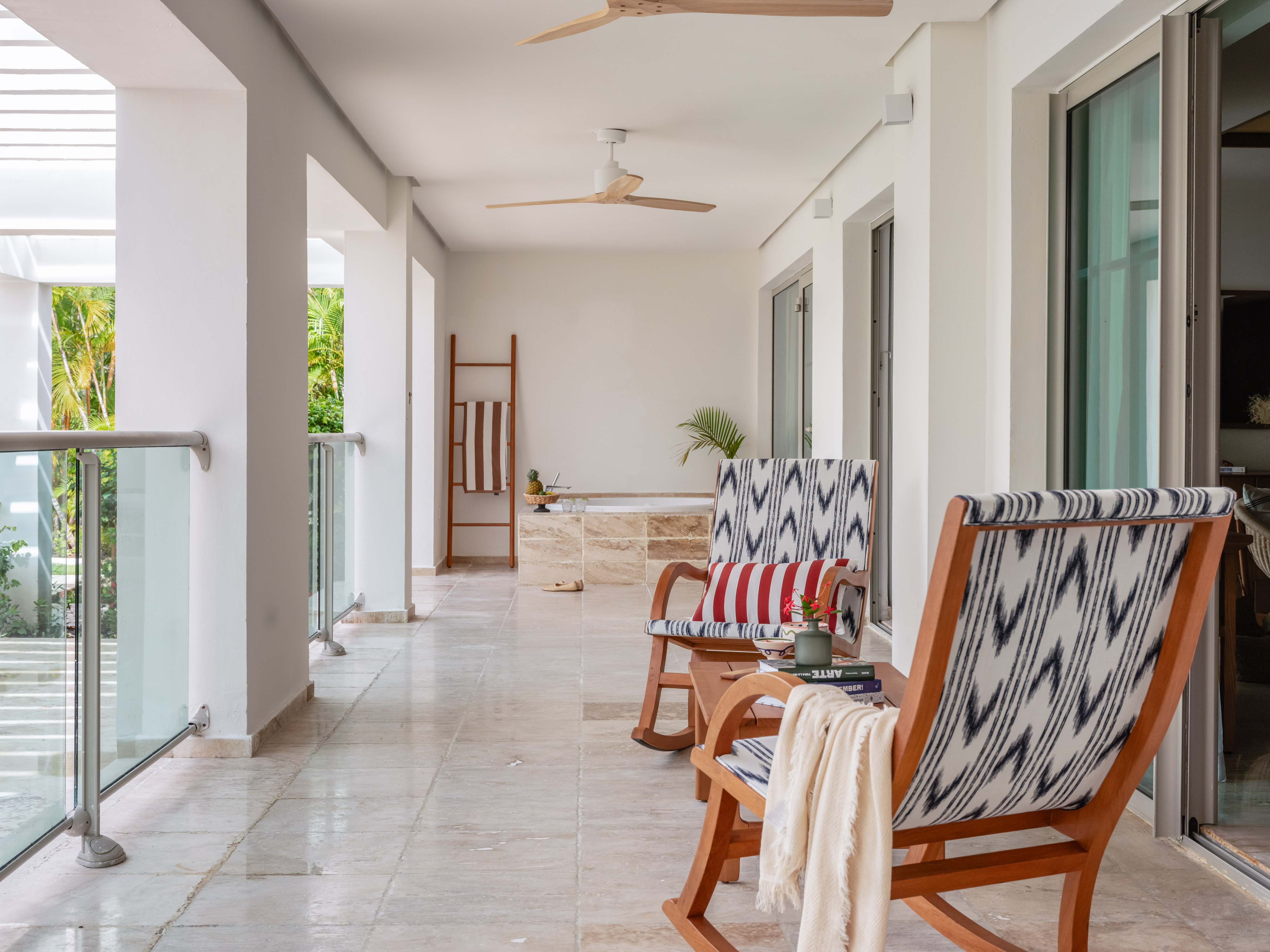 Modern outdoor patio with stylish rocking chairs and tropical views.