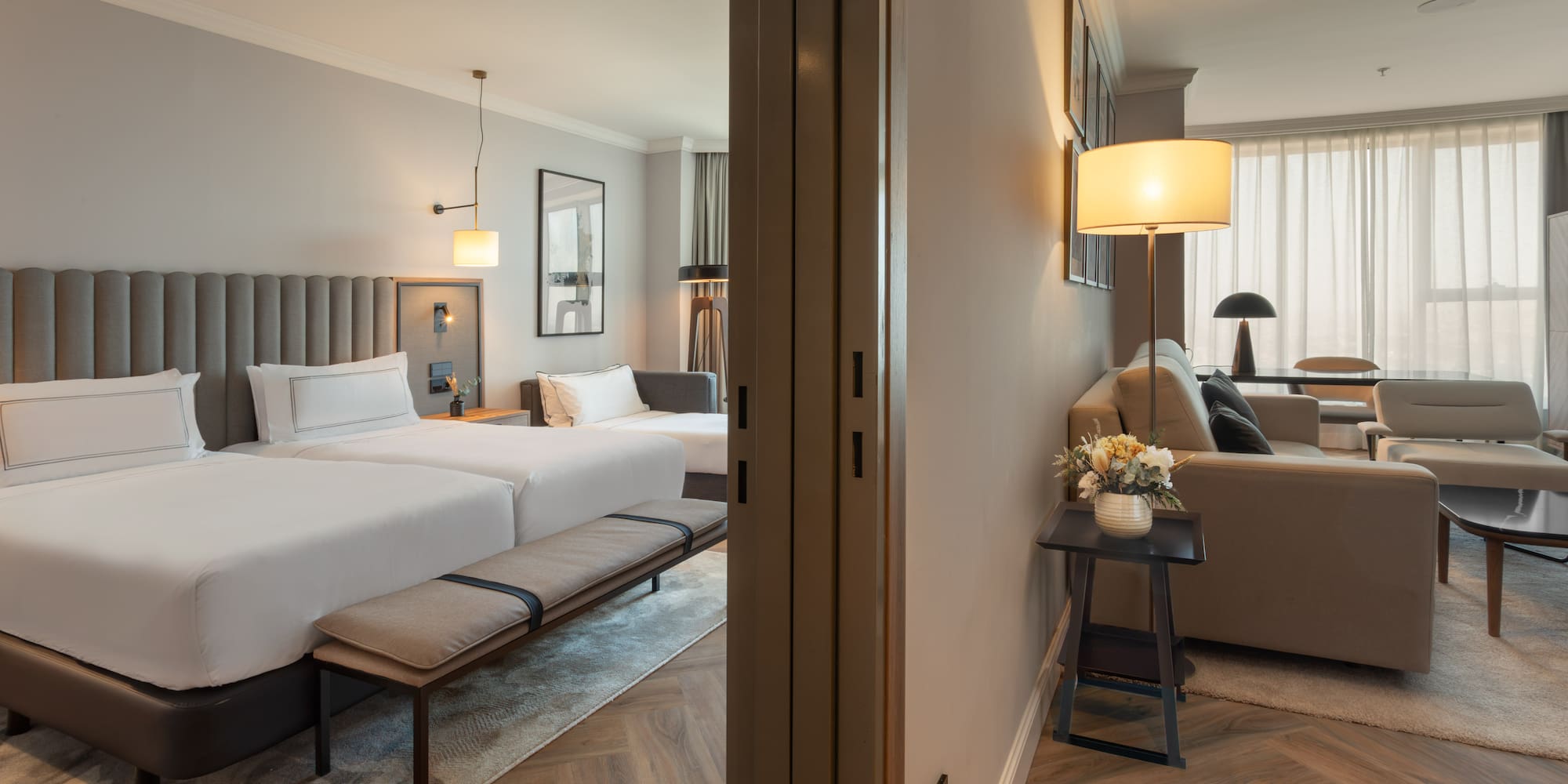 Suite de hotel moderna: dormitorio con dos camas, y sala de estar. Diseño elegante.