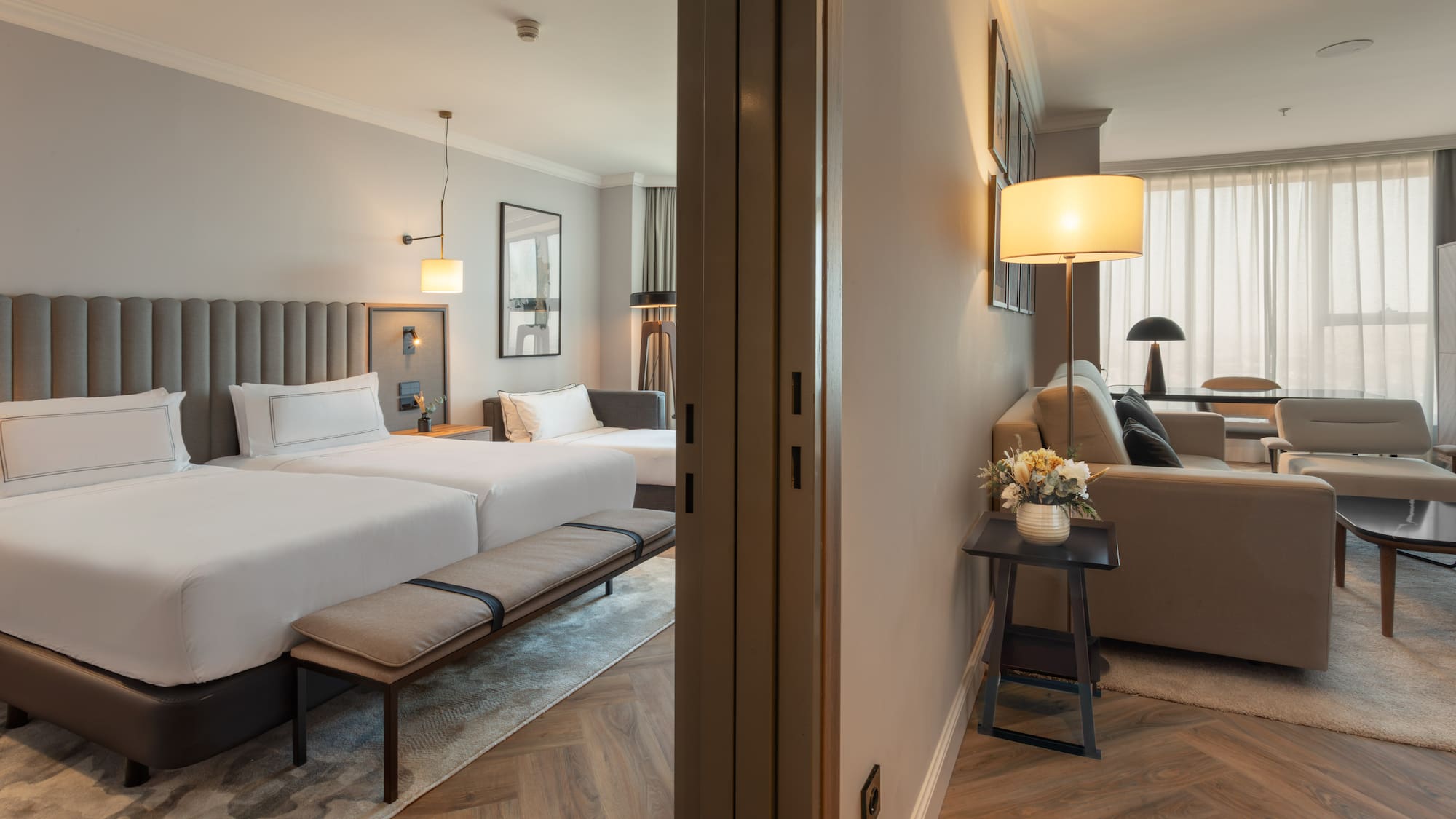 Suite de hotel moderna: dormitorio con dos camas, y sala de estar. Diseño elegante.