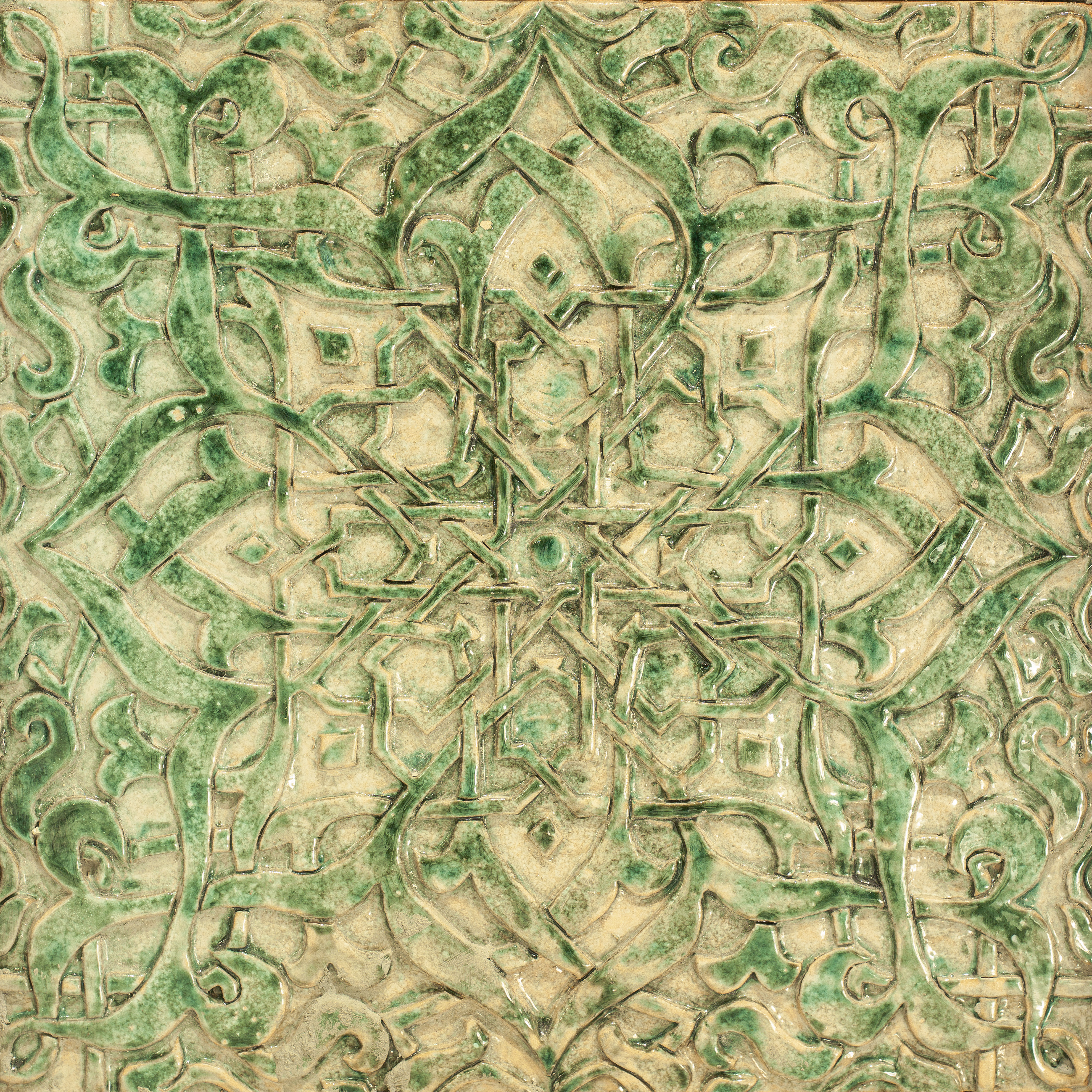 Azulejo cerámico verde con patrón geométrico islámico en relieve.
