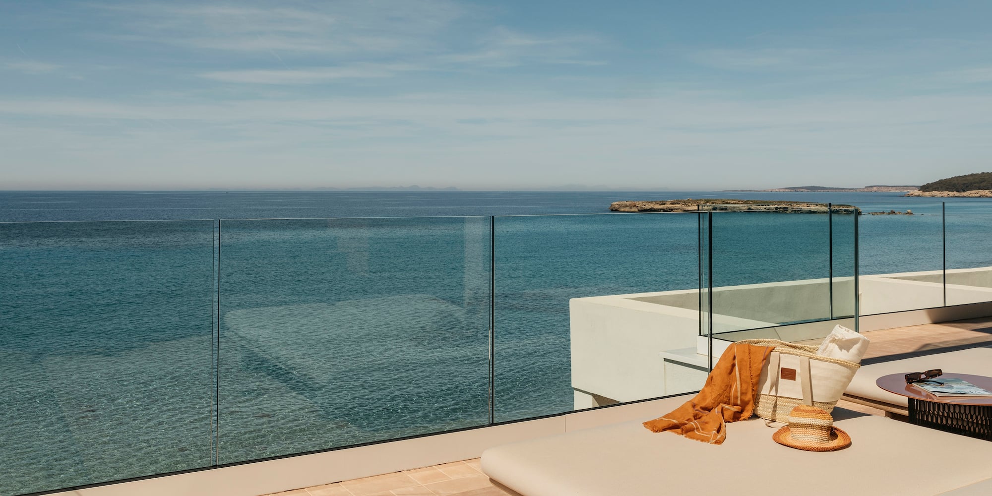 a deck with a glass fence overlooking the ocean