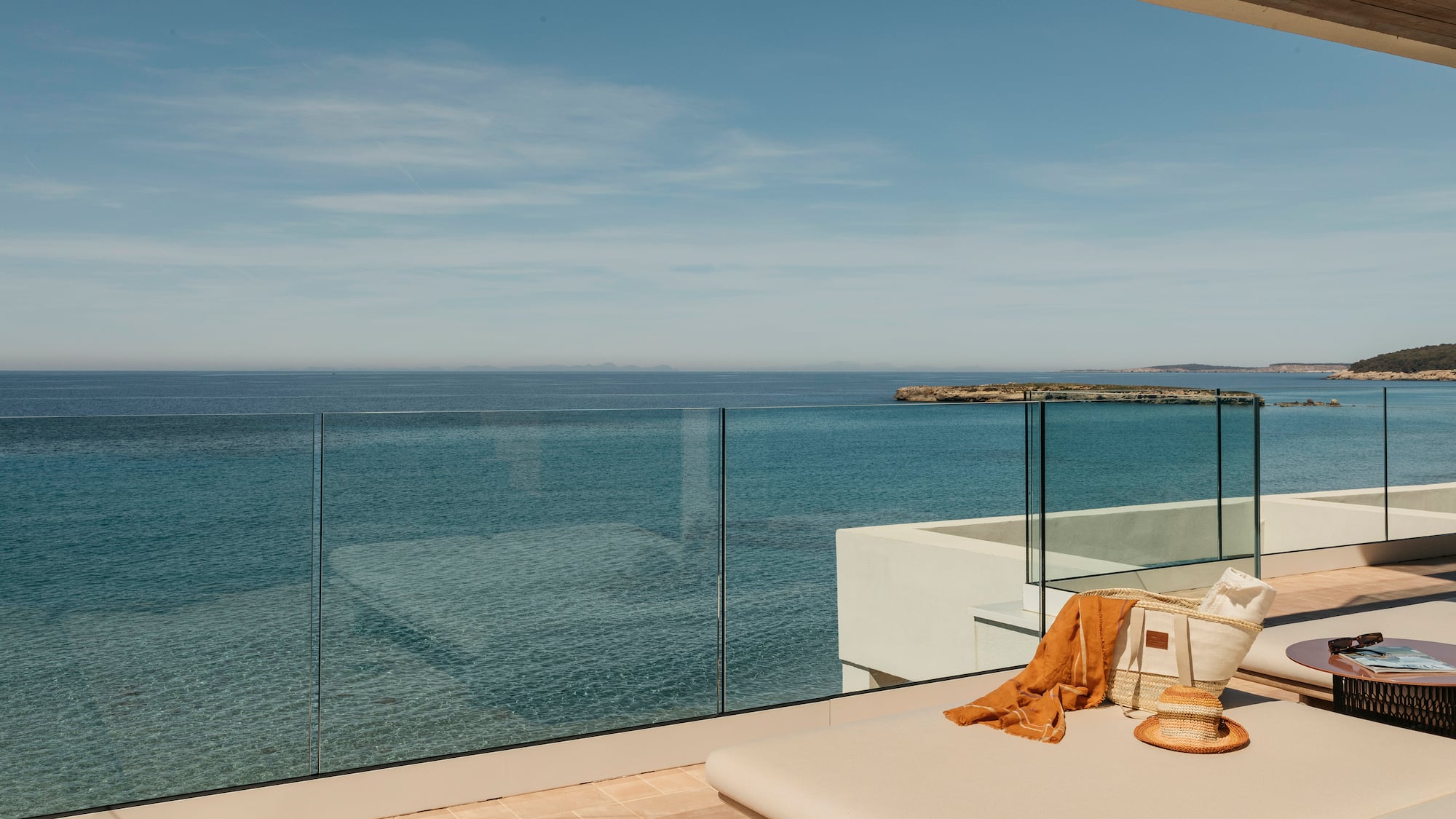 a deck with a glass fence overlooking the ocean