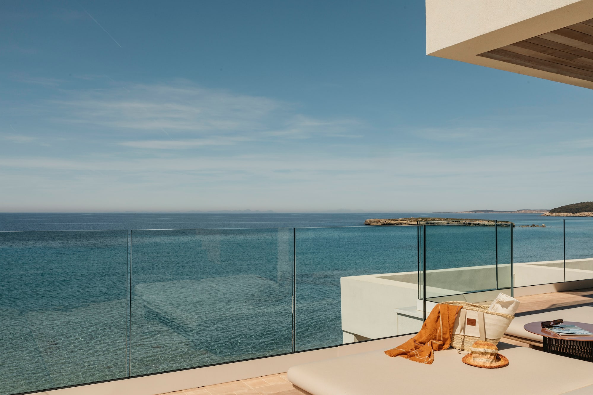 a deck with a glass fence overlooking the ocean