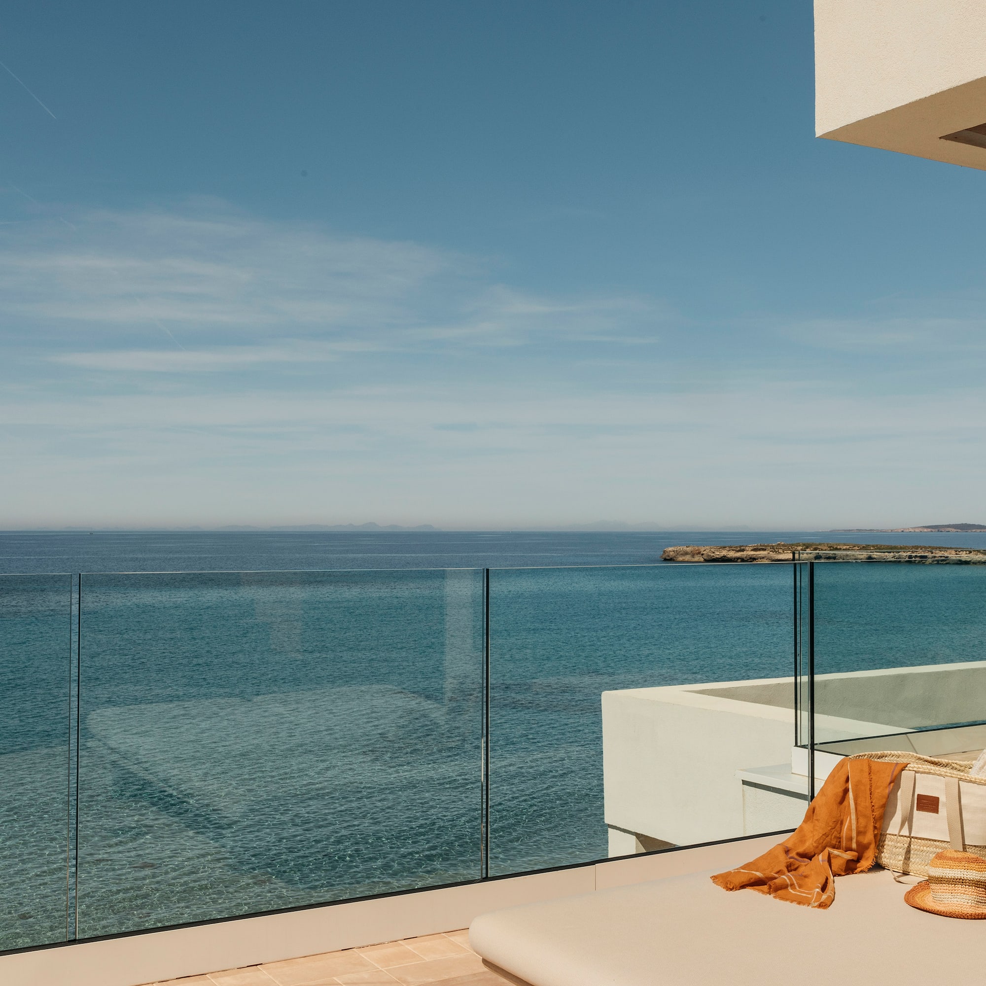a deck with a glass fence overlooking the ocean