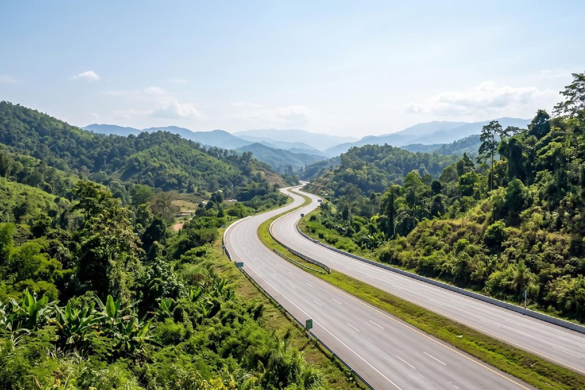 Winding road through lush green forested mountains.